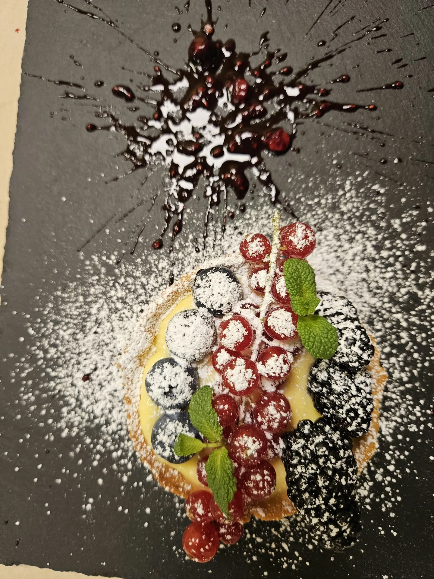 Dessert con frutti di bosco su un piatto scuro